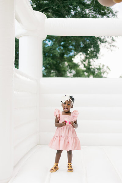Happy little gift smiling in a bounce castle