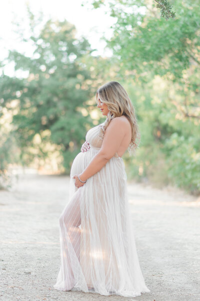 Brown haired three year old laying on the bed and laughing