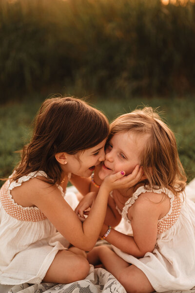 Two sisters laughing together during a joyful outdoor photo session in Pennsylvania