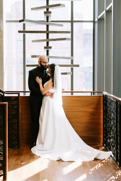A bride and groom share a candid moment on the staircase at the Residence Inn by Marriott in Calgary, Alberta