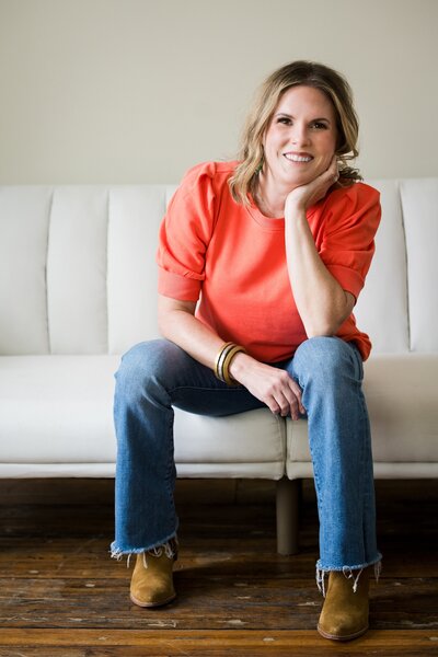 Sarah smiling while sitting on a couch