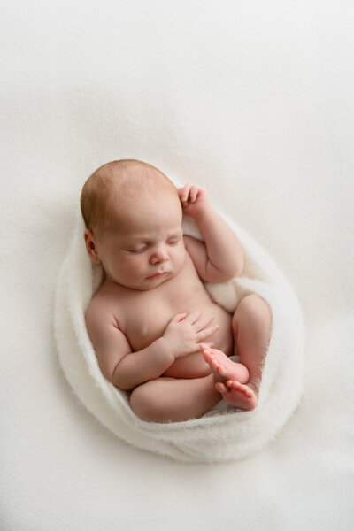 Newborn baby wrapped in soft wrap, photographed in black and white during newborn photoshoot