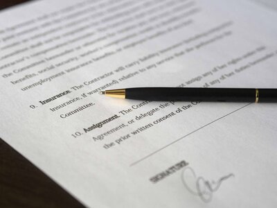 A sleek pen resting on a web design contract, symbolizing agreement and creativity in digital projects.