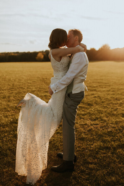Couple lifting bouquet and walking back down the aisle
