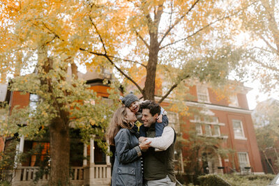 Young family outdoors under fall foliage