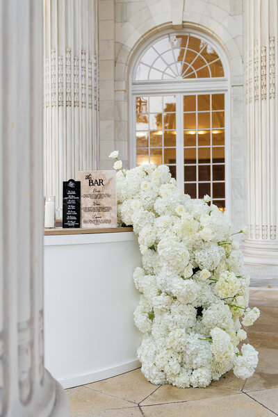 Floral swag on circular bar under portico.