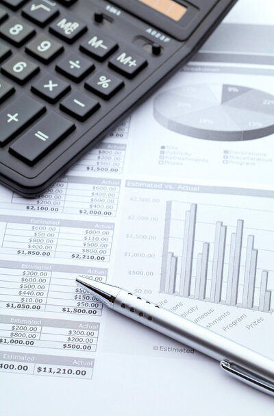 A Dallas business financial advisor assists with funding needs, reviewing a statistics document. The scene includes a calculator and a black pen, essential tools for financial analysis and planning.