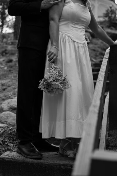 Josh standing behind Ally on stairs during their elopement in Idyllwild, in black and white. Click the image to see more from this elopement