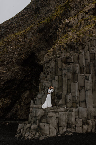 Reynisfjara Iceland Elopement - bride and groom standing on the basalt columns 