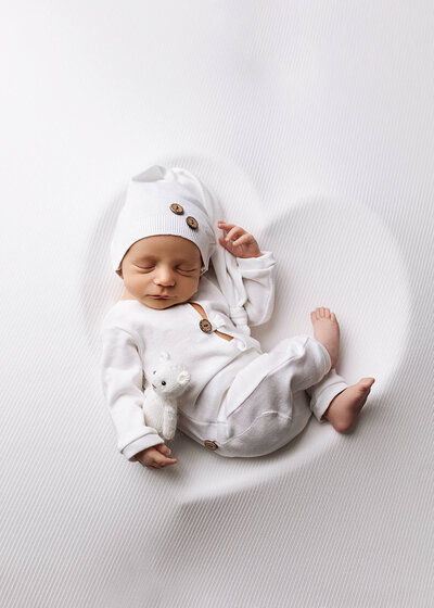 Newborn boy wrapped in white during his newborn session with Jennifer Brandes Photography.