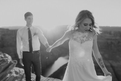 black and white image bride and groom holding hands