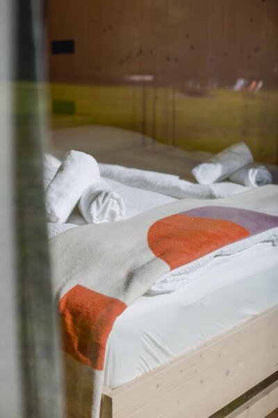 Cozy bed inside a Tiny Home accommodation at TheCampusAlps.com, offering a perfect retreat for adventurers in the Alps.