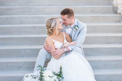 bride and groom touching noses on stairs