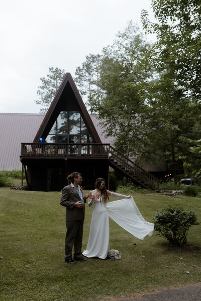 couple sharing a celebratory kiss by a river during an intimate outdoor elopement in early spring