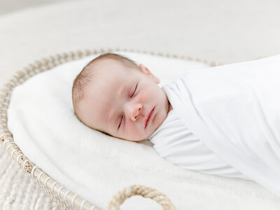 Close up of a newborn baby in bassinet during newborn photography session
