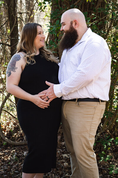Soon-to-be parents posing with their hands on the mother's stomach 
