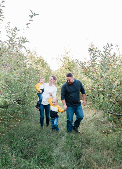 family of four walking through apple trees in Cleveland, TN