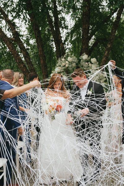 bride and groom walking down the aisle through streamers 