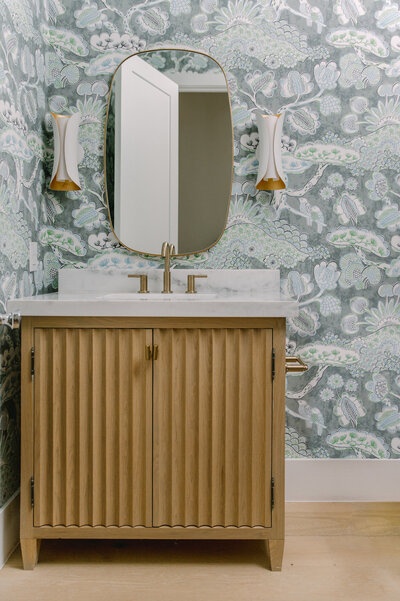 Mirror and Sink of a bathroom with designer wallpaper