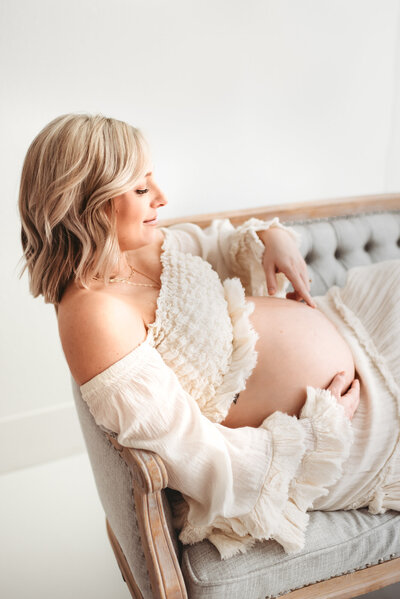pregnant mom and son listening to baby belly during maternity photography session
