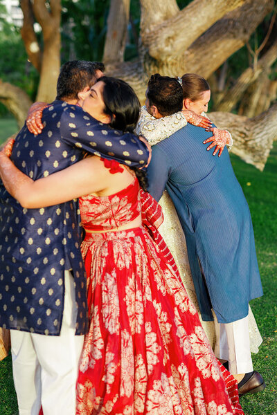 Newlyweds hugging wedding guests 