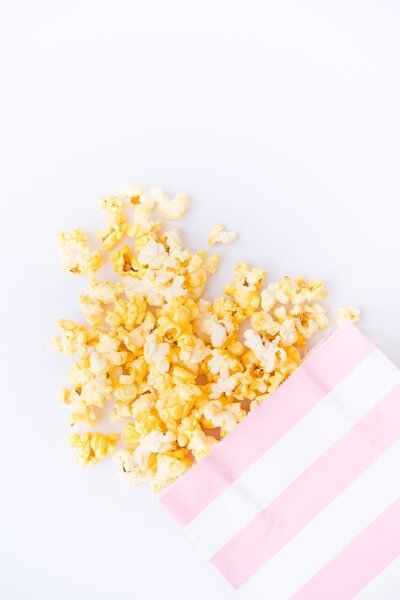 popcorn spilling from a striped pink and white bag