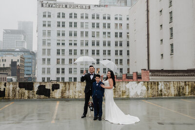 A family with umbrellas before their Vancouver BC wedding