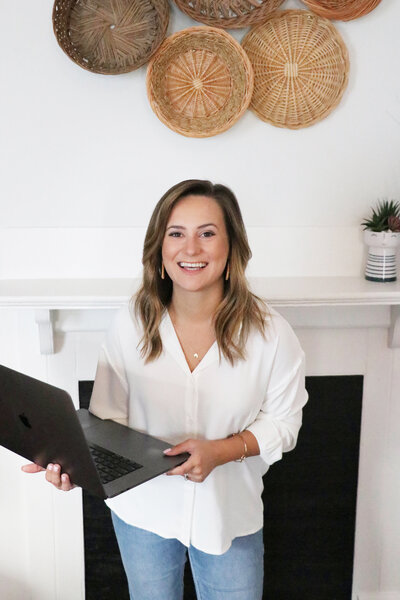 woman holding laptop while smiling
