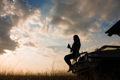 Annie sitting on a safari vehicle at sunset