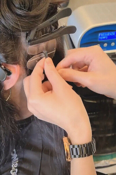 Hair specialist applying Great Lengths hair extensions to dark brown hair using precision tools at Blake & Kwan Hair Salon in Sutherland Shire.