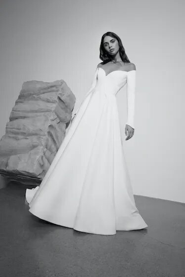Bride in a long-sleeve off-the-shoulder gown with full skirt.