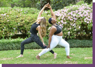 two women doing yoga pose on the grass