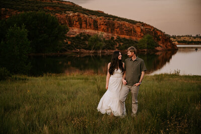 A couple laughing and embracing by Horsetooth Reservoir during the fall 