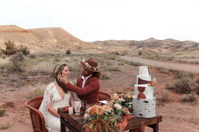 bride and groom sitting at table posing