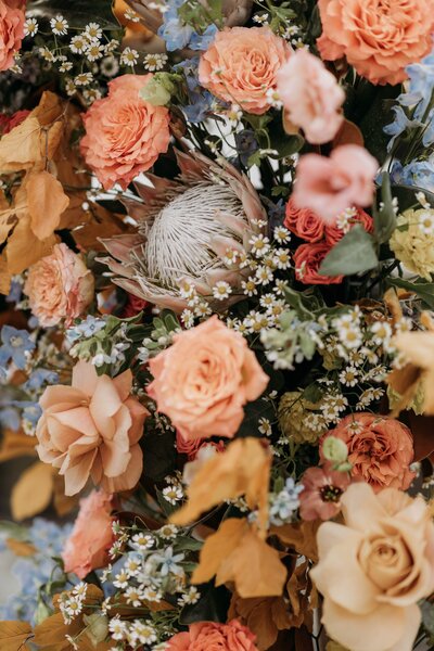 Floral accents styled into a wedding lounge setup to create a cozy, immersive atmosphere for a fall wedding in Fort Worth.