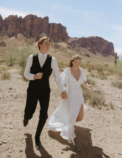 destination wedding photography in Utah bride and groom running in mountains