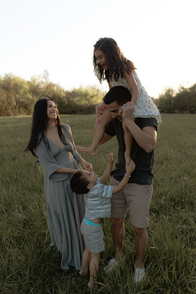 family photo session located in columbia tennessee where parents are watching their kids play ring around the rosie