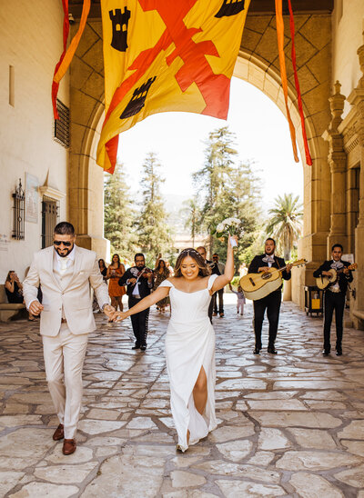 bride and groom lead wedding party through Santa Barbara Courthouse