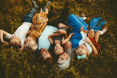 Andi Sweeny laying in a field with her partner and their children