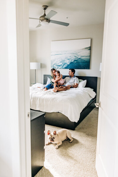 Candid photo of a family in thier home with a cute dog and a playful moment.