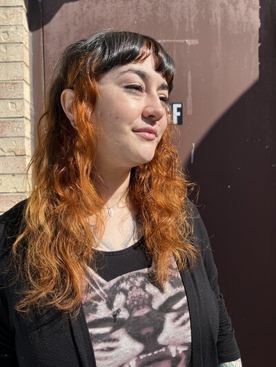 Image of client with dark, black hair that has been dyed orange.