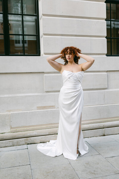 black and white image bride wearing strapless satin wedding dress with long train