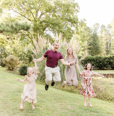 family of 4 jump for joy during family photography session
