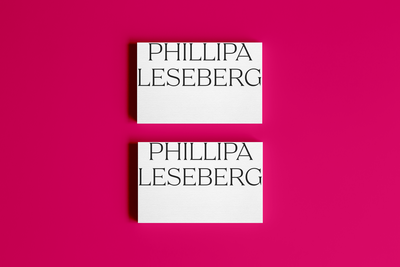 Two white cards with the name "PHILLIPA LESEBERG" in bold black letters, showcased on a bright pink background—perfect for brand design inspiration from Sweet Pea Ink Creative.