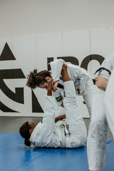Two women in gis drilling on the mat at IRONGRIP jiu jitsu in Raleigh 