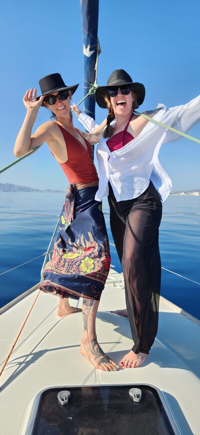 explore and expand small group travel leaders smiling on private boat tour for greek island yoga retreat