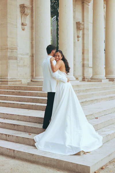 Bride hugs groom on steps of Rodin Museum in Philadelphia