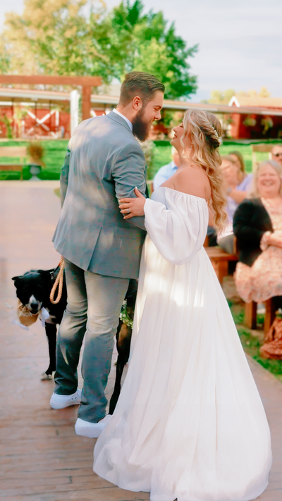 bride and groom playing with their dog on the aisle, laughing