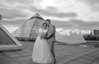 bride and groom standing onto the muttart roof of edmonton alberta, black and white filter