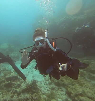 Woman waves to camera during a scuba diving excursion in the Florida Keys.